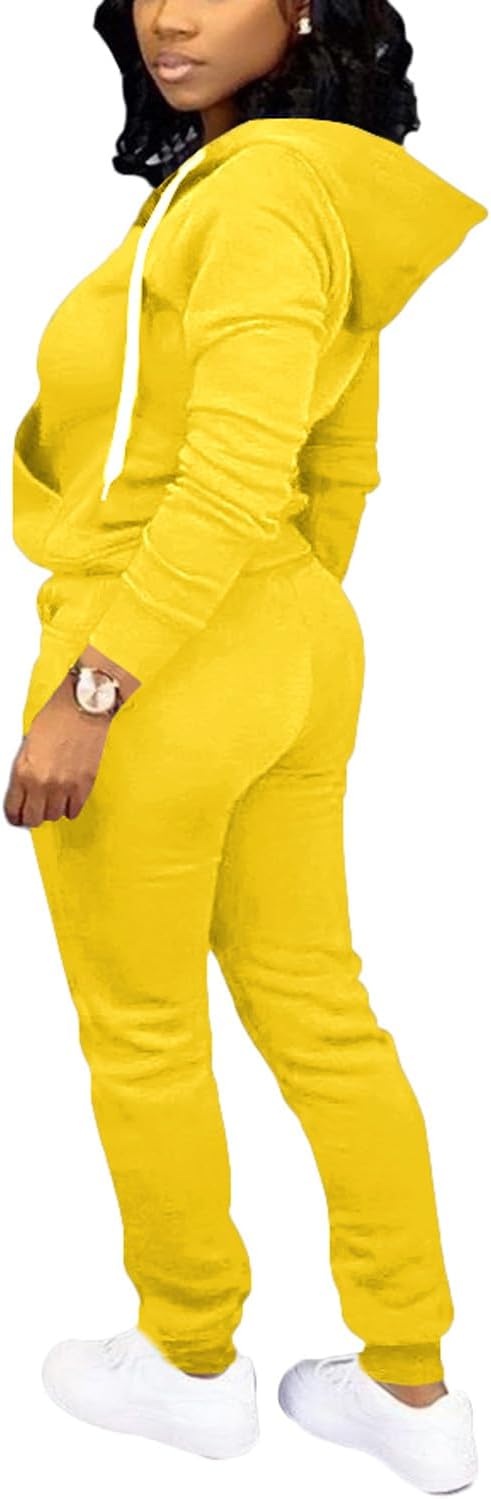 Frau in gelbem Jogginganzug mit Kapuze, weiße Sneaker, sportlich, bequem, Freizeitmode.