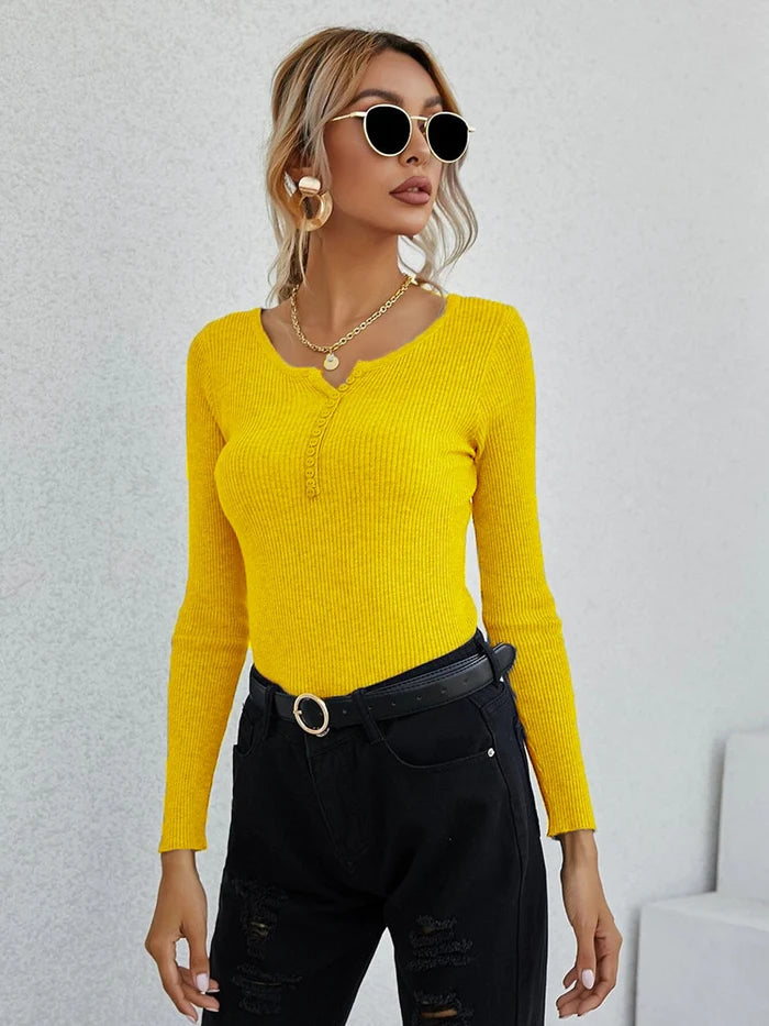 Frau in gelbem V-Ausschnitt-Pullover, schwarze Hose, Sonnenbrille, modisch, elegant.