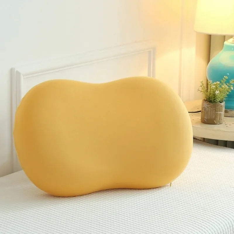 Gelbes ergonomisches Kissen auf Bett, ideal für Nackenunterstützung und Komfort im Schlafzimmer.
