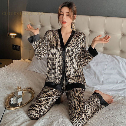 Frau in gemustertem Pyjama auf Bett, schwarz-goldenes Design, luxuriöse Nachtwäsche.