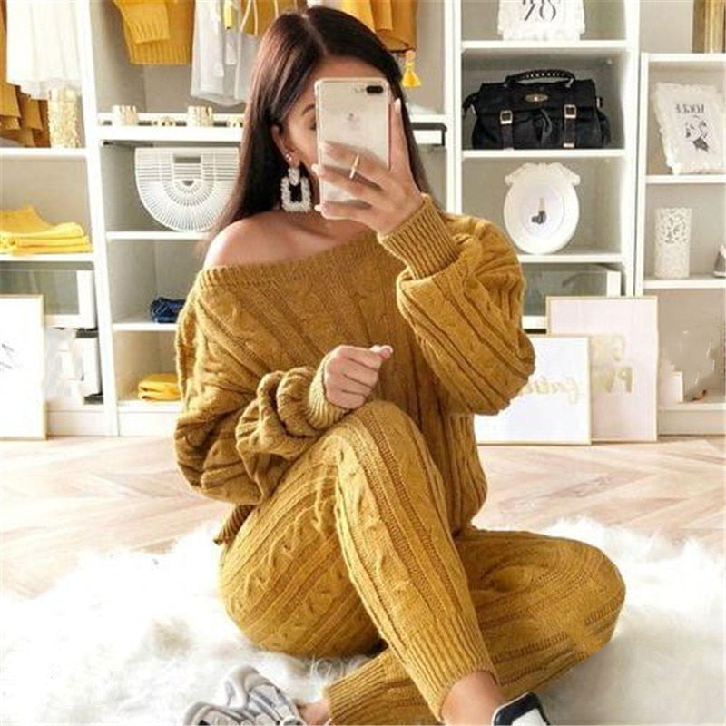 Frau in senfgelbem Strickpullover und Hose, gemütliches Herbstoutfit, Selfie im Wohnzimmer.