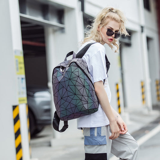 Frau mit geometrischem Rucksack, leuchtet im Dunkeln, modisch, urbaner Stil, dreieckiges Muster.