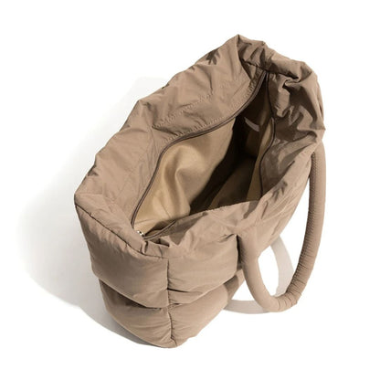Beigefarbene, gesteppte Handtasche aus Stoff mit Reißverschluss, modisch und geräumig.