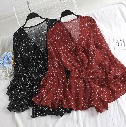 Zwei gepunktete Chiffon-Kleider, schwarz und rot, mit Rüschenärmeln auf weißem Hintergrund.