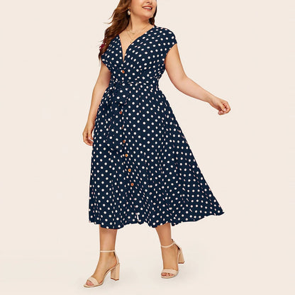 Frau in blauem gepunktetem Kleid, knielang, mit V-Ausschnitt, Sommermode, elegant.