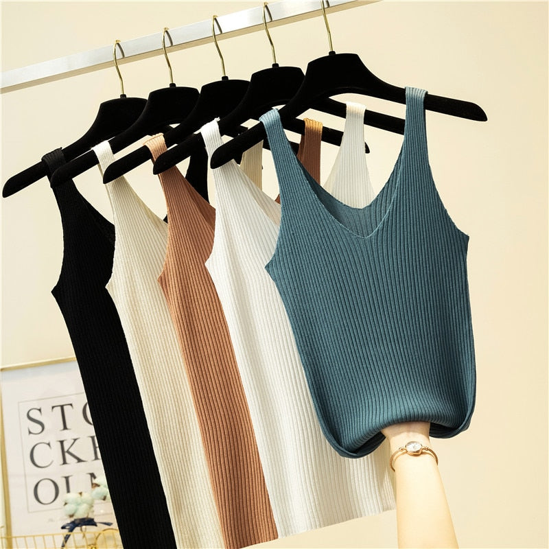 Fünf gerippte Damen-Tanktops in Schwarz, Braun, Weiß und Blau auf Kleiderbügeln.