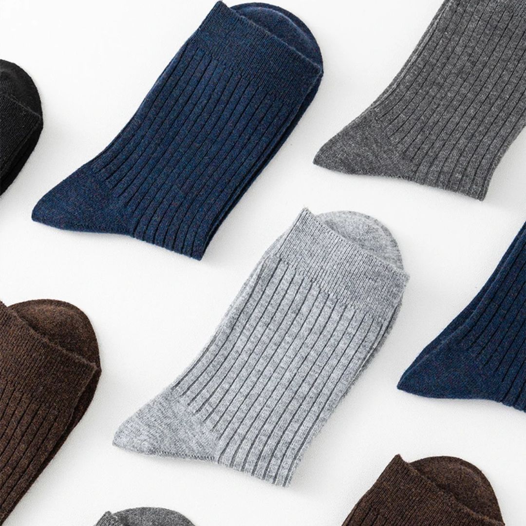 Mehrfarbige gerippte Herrensocken aus Baumwolle, flach ausgelegt auf weißem Hintergrund.