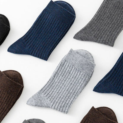 Mehrfarbige gerippte Herrensocken aus Baumwolle, flach ausgelegt auf weißem Hintergrund.