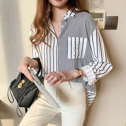 Frau in gestreifter Bluse mit schwarzer Handtasche und weißer Hose, modisch, elegant.
