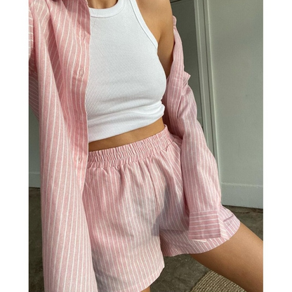 Frau in rosa gestreiftem Pyjama-Set, langärmliges Hemd und Shorts, bequem, modisch.