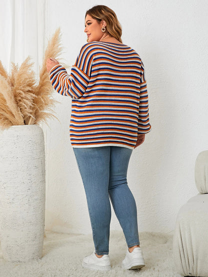 Frau in gestreiftem Pullover und Jeans, steht neben Pampasgras, lässige Mode, gemütliches Outfit.