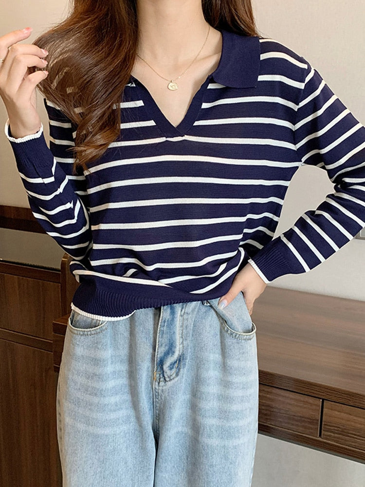 Frau in blau-weiß gestreiftem Pullover und Jeans, lässige Mode, Freizeitkleidung.