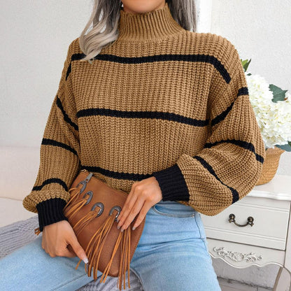 Frau in gestreiftem Strickpullover, beige und schwarz, mit brauner Fransenhandtasche.