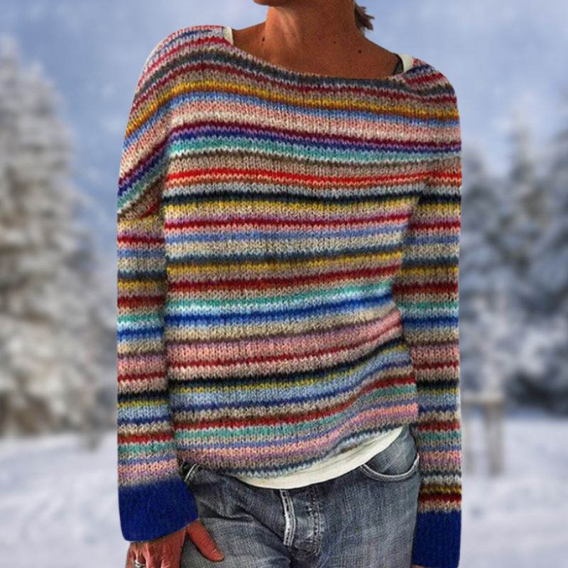 Frau in gestreiftem Pullover, bunte Streifen, Wintermode, lässiger Stil, Jeans, Schnee im Hintergrund.