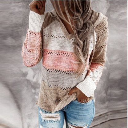 Frau trägt gestreiften Strickpullover in Rosa und Beige, kombiniert mit zerrissenen Jeans.