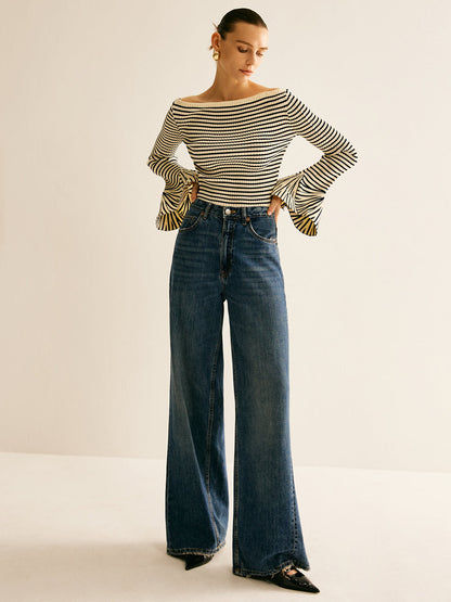Frau in gestreiftem Pullover und blauer Schlaghose, modisch, elegant, Damenmode, Herbstlook.