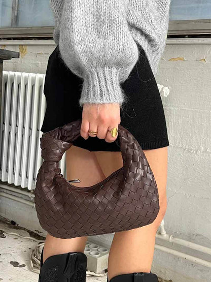 Frau mit brauner geflochtener Ledertasche, modisches Accessoire, Herbstmode.