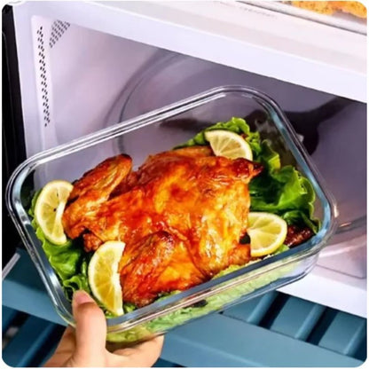 Glasbehälter mit gebratenem Hähnchen, Zitronenscheiben und Salat in der Mikrowelle.