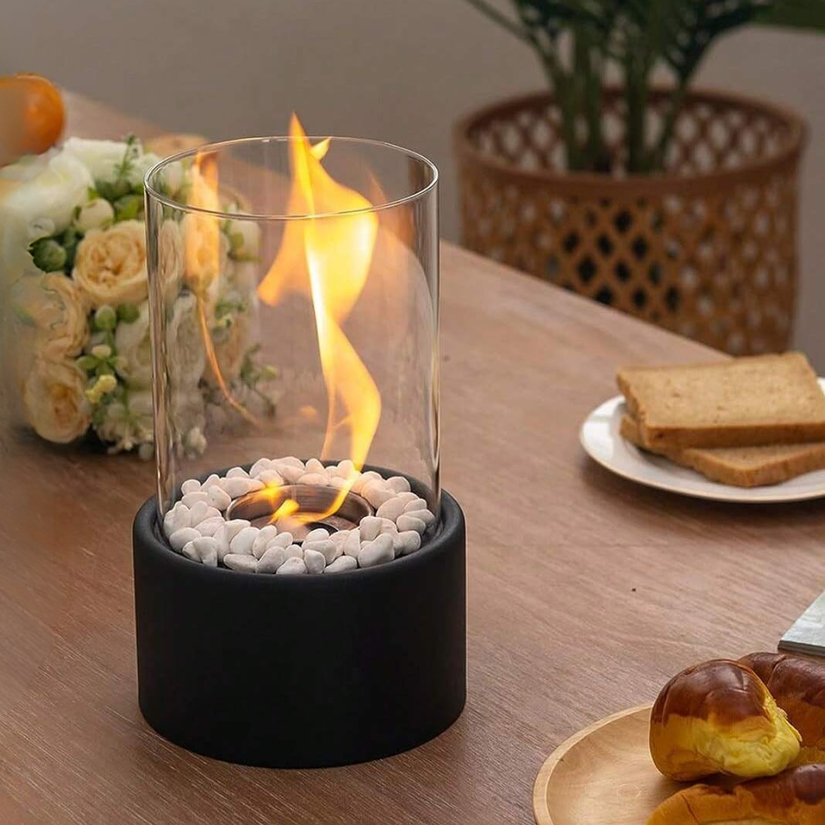 Glas-Öllampe mit Flamme, schwarzer Sockel, weiße Steine, Tischdekoration, modern, elegant.