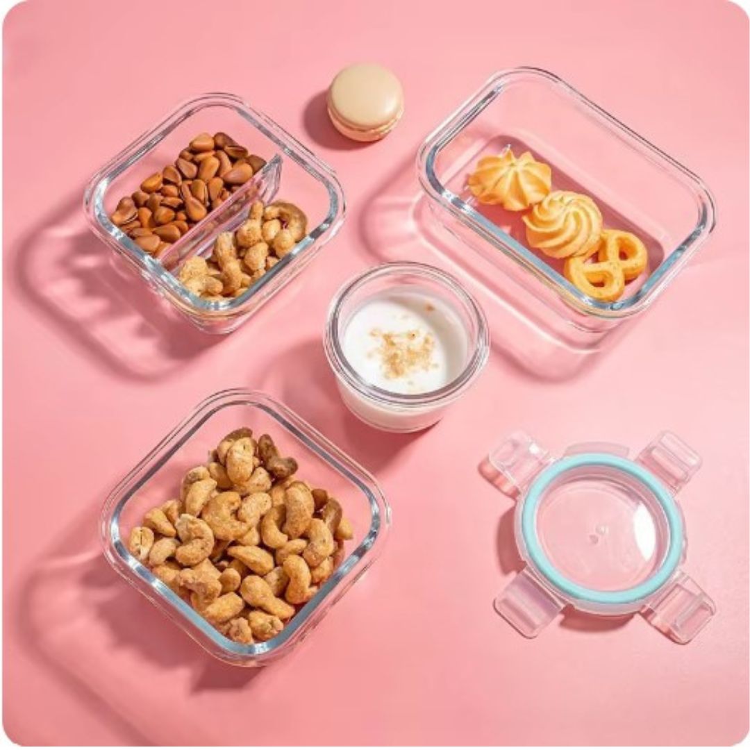 Glasbehälter mit Nüssen, Keksen und Joghurt auf rosa Hintergrund, luftdicht, stapelbar.