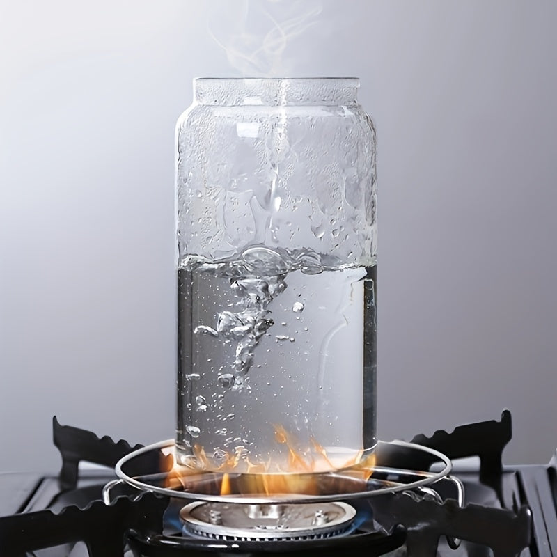 Glasgefäß mit kochendem Wasser auf Gasherd, Dampf steigt auf, transparente Küche.