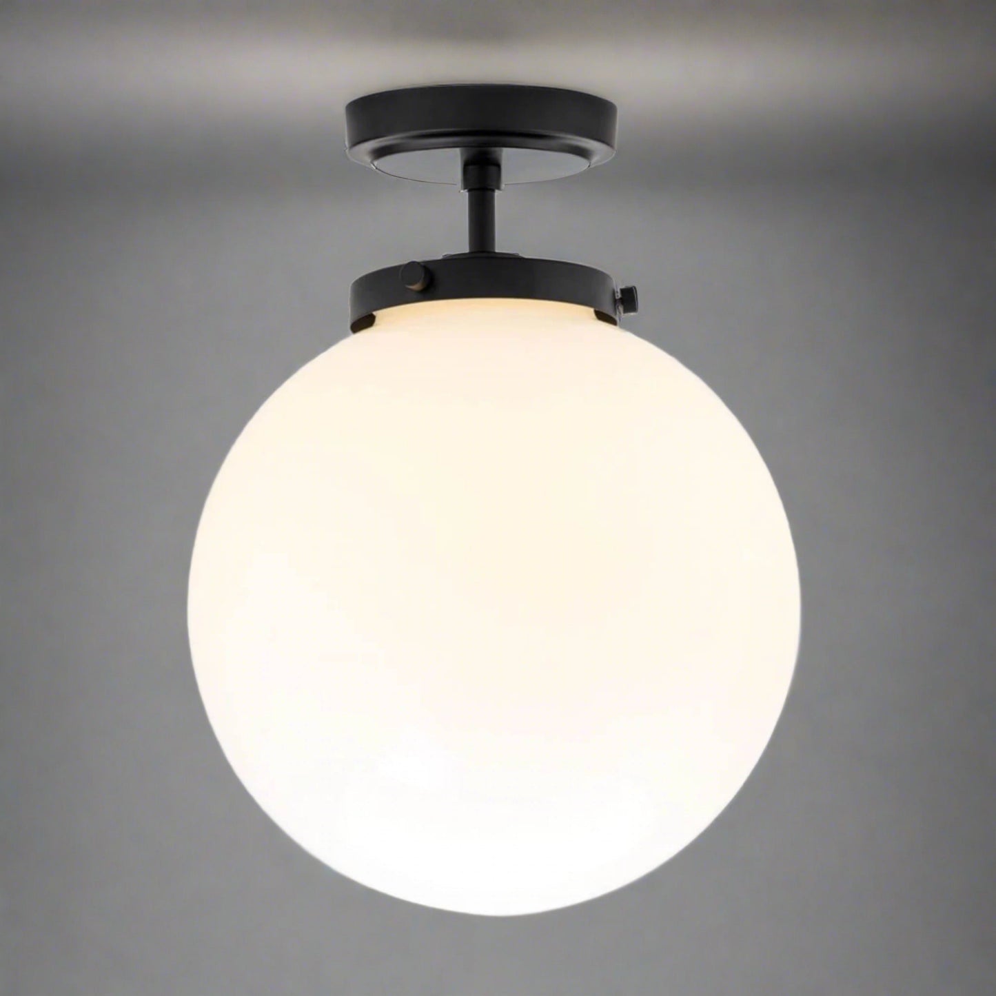 Schwarze Deckenleuchte mit weißem Glaskugel-Schirm, modernes Design, für Badezimmer geeignet.