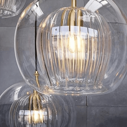 Moderne Glaspendelleuchte mit goldenen Akzenten, transparentes Design, elegantes Wohnaccessoire.