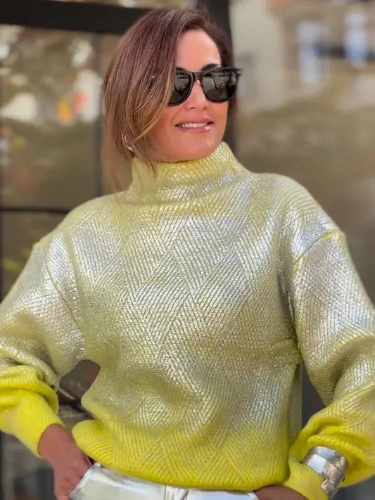 Frau in gelbem, metallischem Strickpullover mit hohem Kragen und langen Ärmeln, modisch elegant.