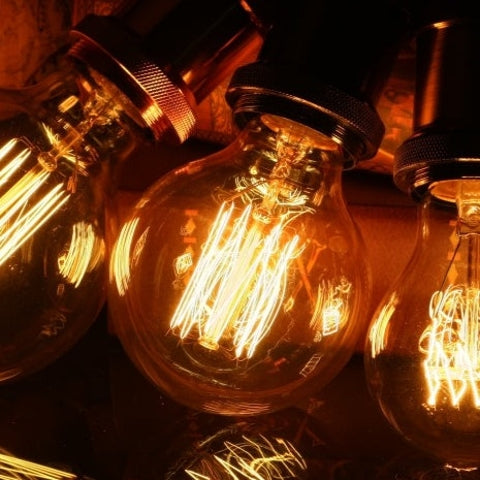 Drei Vintage-Glühbirnen mit warmem Licht und sichtbaren Filamenten, Retro-Beleuchtung.
