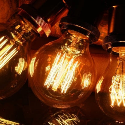 Drei Vintage-Glühbirnen mit warmem Licht und sichtbaren Filamenten, Retro-Beleuchtung.