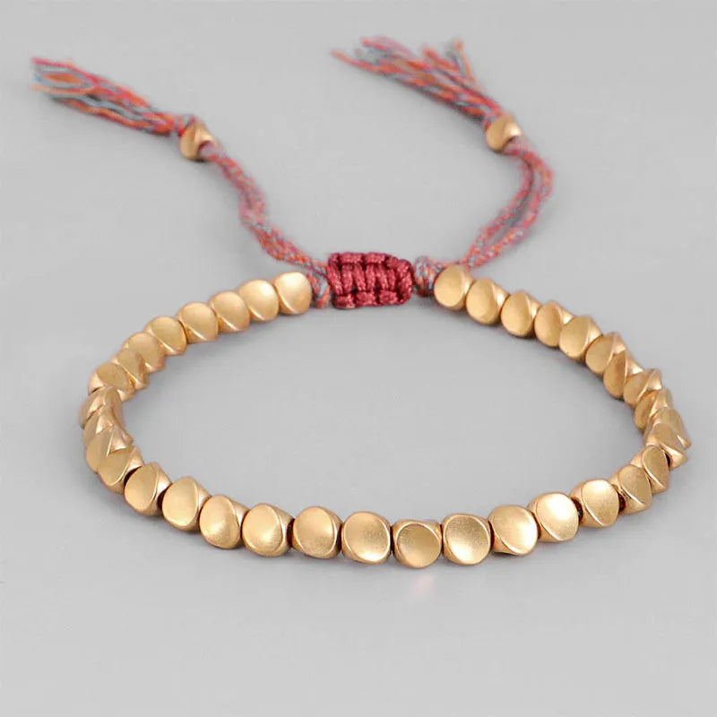 Goldenes Armband mit runden Perlen und rotem verstellbarem Kordelverschluss, handgefertigt.