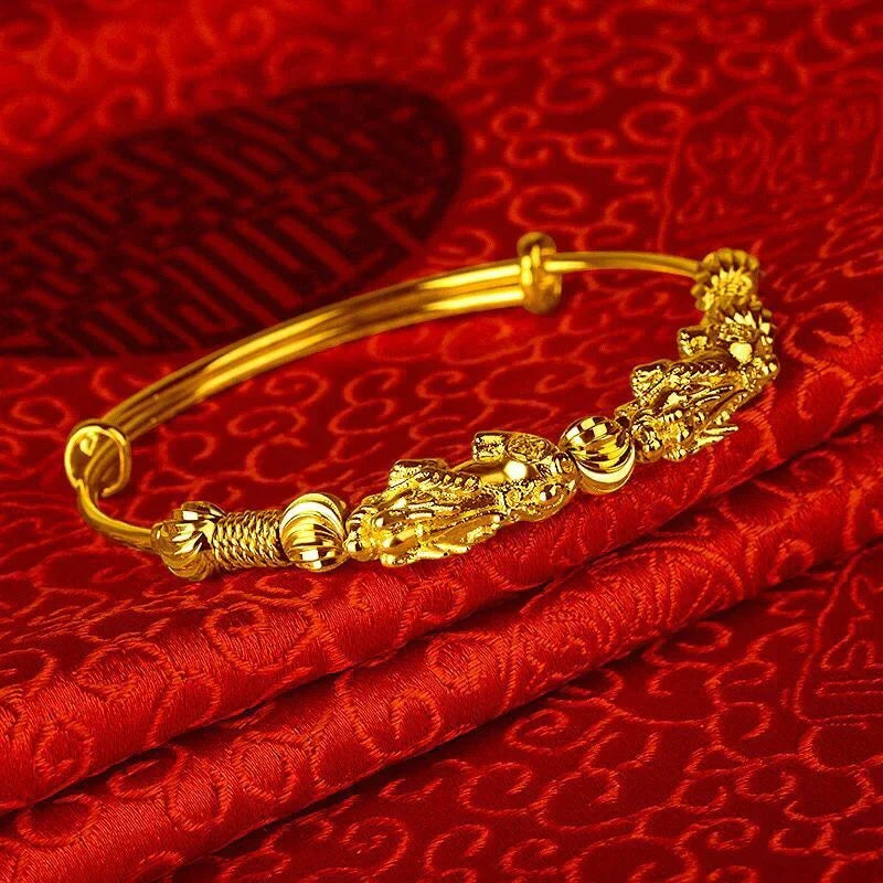 Goldenes Armband mit Drachenmotiv auf rotem Seidenstoff, chinesisches Design, Schmuckaccessoire.