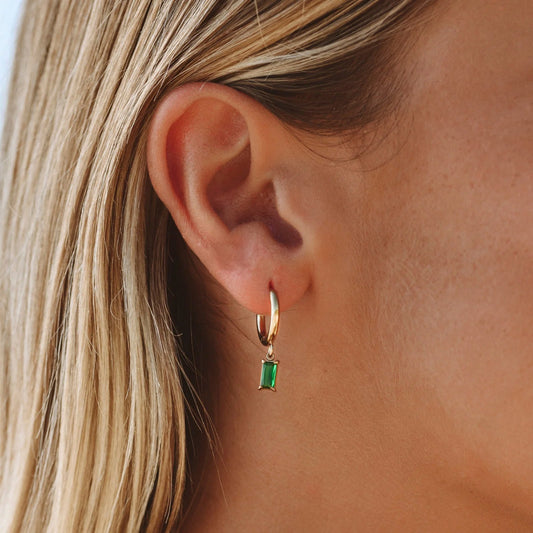 Goldene Ohrringe mit grünem Edelstein, eleganter Schmuck für Damen.