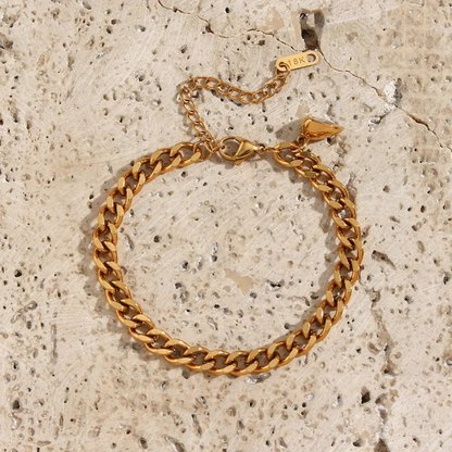 Goldenes Armband aus Edelstahl, Kettenglied-Design, verstellbar, auf hellem Steinuntergrund.
