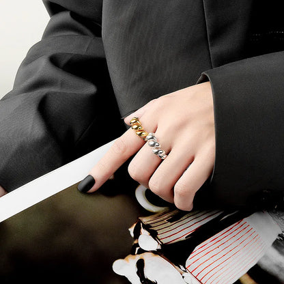 Damenhand mit gold-silbernem Ring, elegantes Schmuckdesign, stilvoller Look, Nahaufnahme.