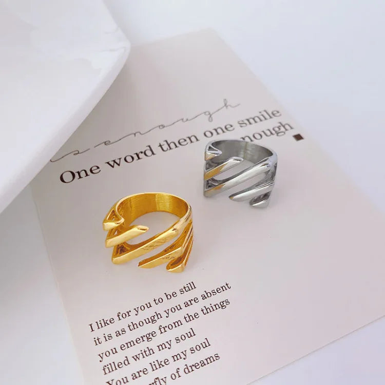 Zwei offene Ringe, gold und silber, auf Papier mit Zitat, modisches Schmuckdesign.