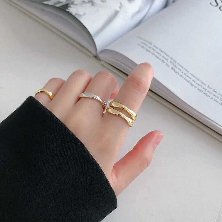 Drei goldene und silberne Ringe an Hand, modisches Schmuckdesign, Nahaufnahme.