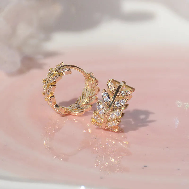 Goldene Ohrringe mit Blattdesign, Zirkonia-Steinen, eleganter Schmuck, Damenaccessoire.