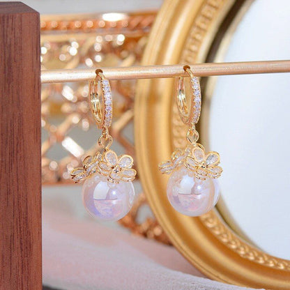 Goldene Ohrringe mit Perlenanhänger, elegantes Design, Schmuck für Damen, modisch und luxuriös.