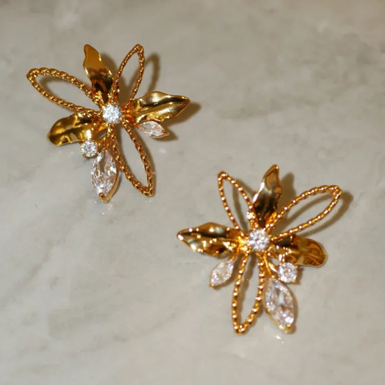 Goldene Ohrringe mit Blumenmotiv, funkelnde Kristalle, eleganter Schmuck für Damen.