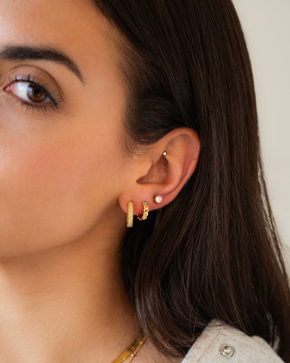 Frau mit goldenen Creolen und Ohrstecker, Schmuck, Modeaccessoire, eleganter Stil.