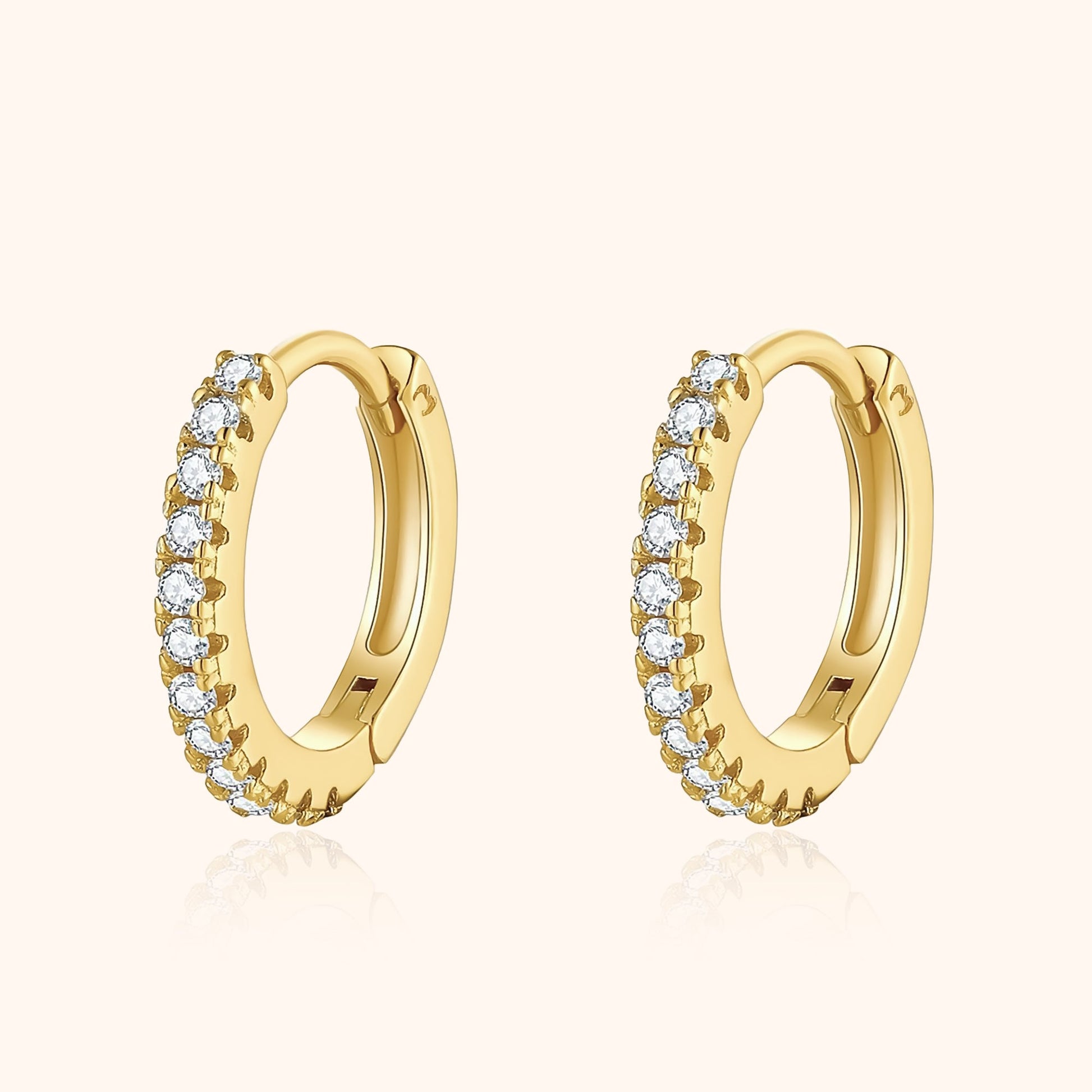 Goldene Creolen mit Diamanten, eleganter Schmuck, luxuriöse Ohrringe, modisches Accessoire.