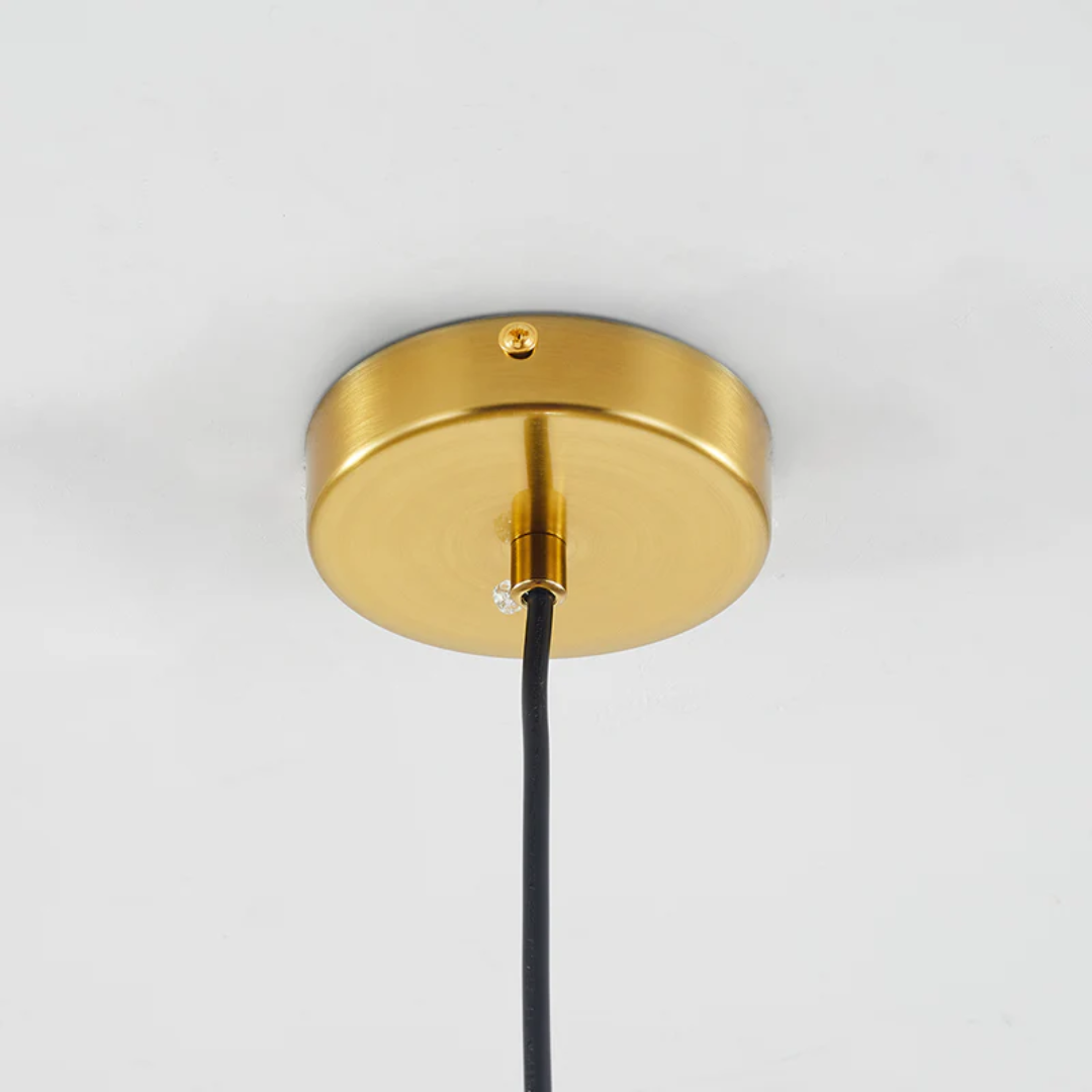 Goldene Deckenrosette aus Metall mit schwarzem Kabel für moderne Beleuchtung.