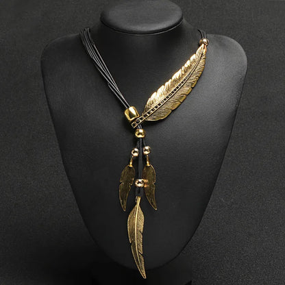 Goldene Feder Halskette auf schwarzem Hintergrund, elegantes Schmuckdesign, Damenmode.