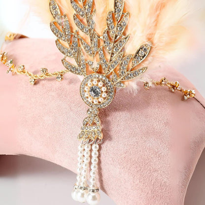 Goldene Strass-Haarspange mit Perlen und Federn auf rosa Hintergrund, eleganter Haarschmuck.