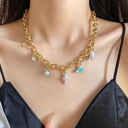 Goldene Halskette mit Muschel- und Perlenanhängern, modisches Schmuckstück für Damen.