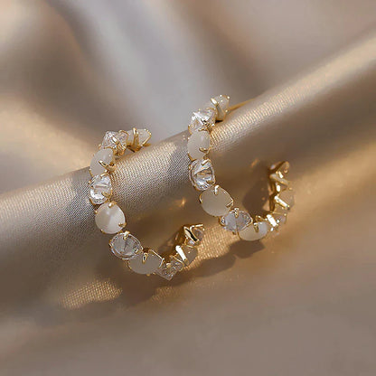 Goldene Creolen mit weißen Kristallen, eleganter Schmuck, modische Ohrringe für Damen.