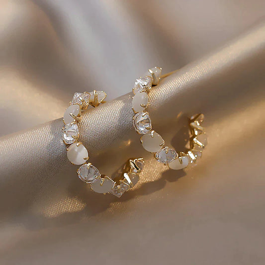 Goldene Creolen mit weißen Kristallen, eleganter Schmuck, modische Ohrringe für Damen.