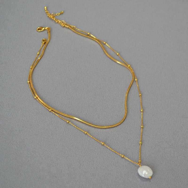 Goldene Halskette mit Perlenanhänger, elegantes Schmuckdesign, Damenaccessoire, modisch.