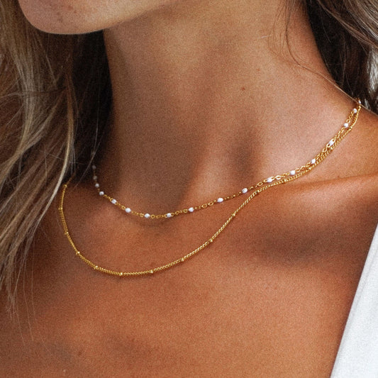Goldene, mehrschichtige Choker-Halskette, Damenmode, eleganter Schmuck, Perlenakzente.